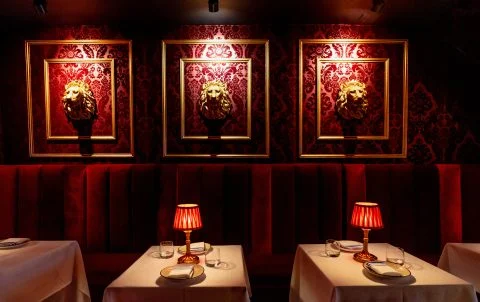 Candlelit table with dry-aged steak and red wine at Andrew Steak Society, upscale restaurant in the East Village NYC